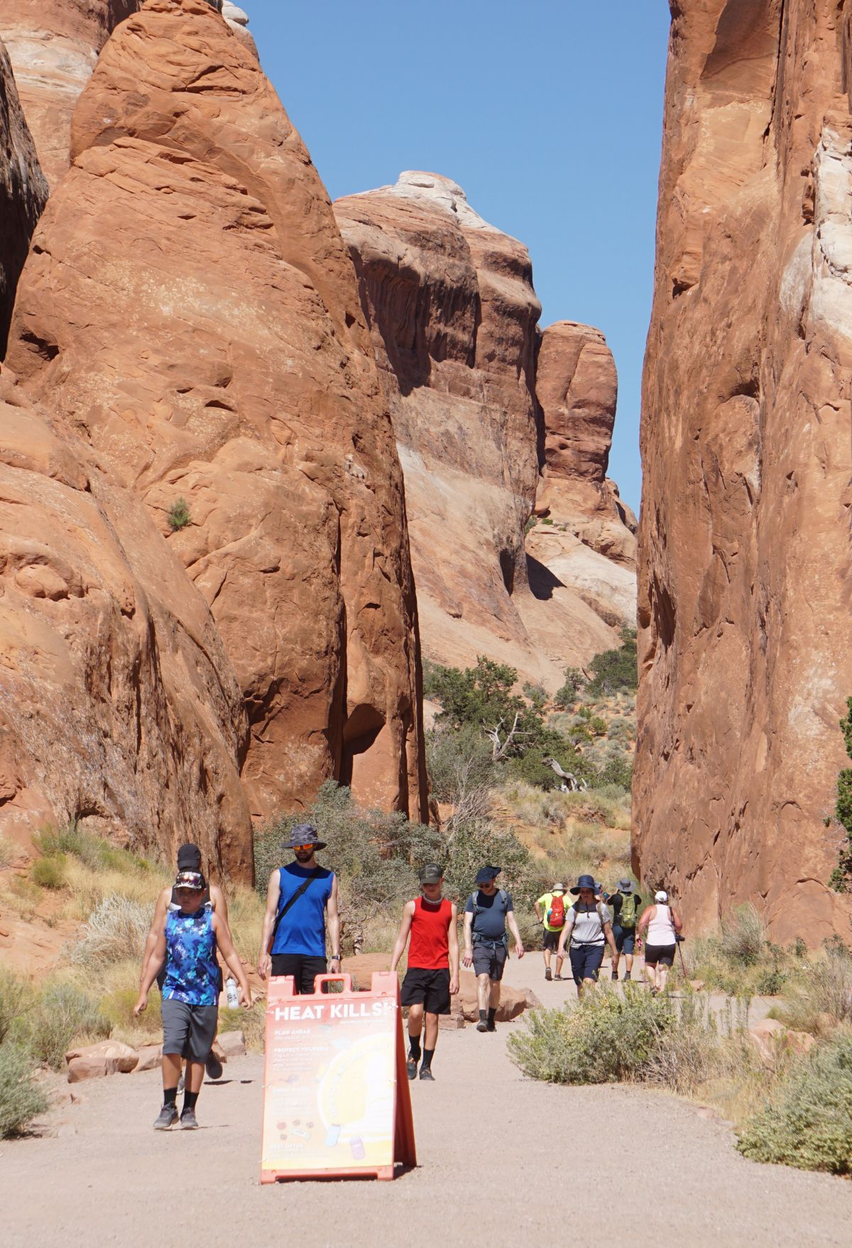 A group of people walking in Devils garden Arches national park, utah.