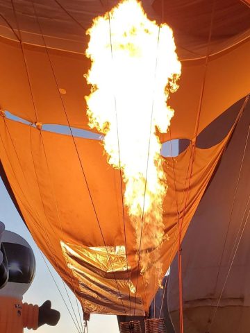 A hot air balloon with flames coming out of it.