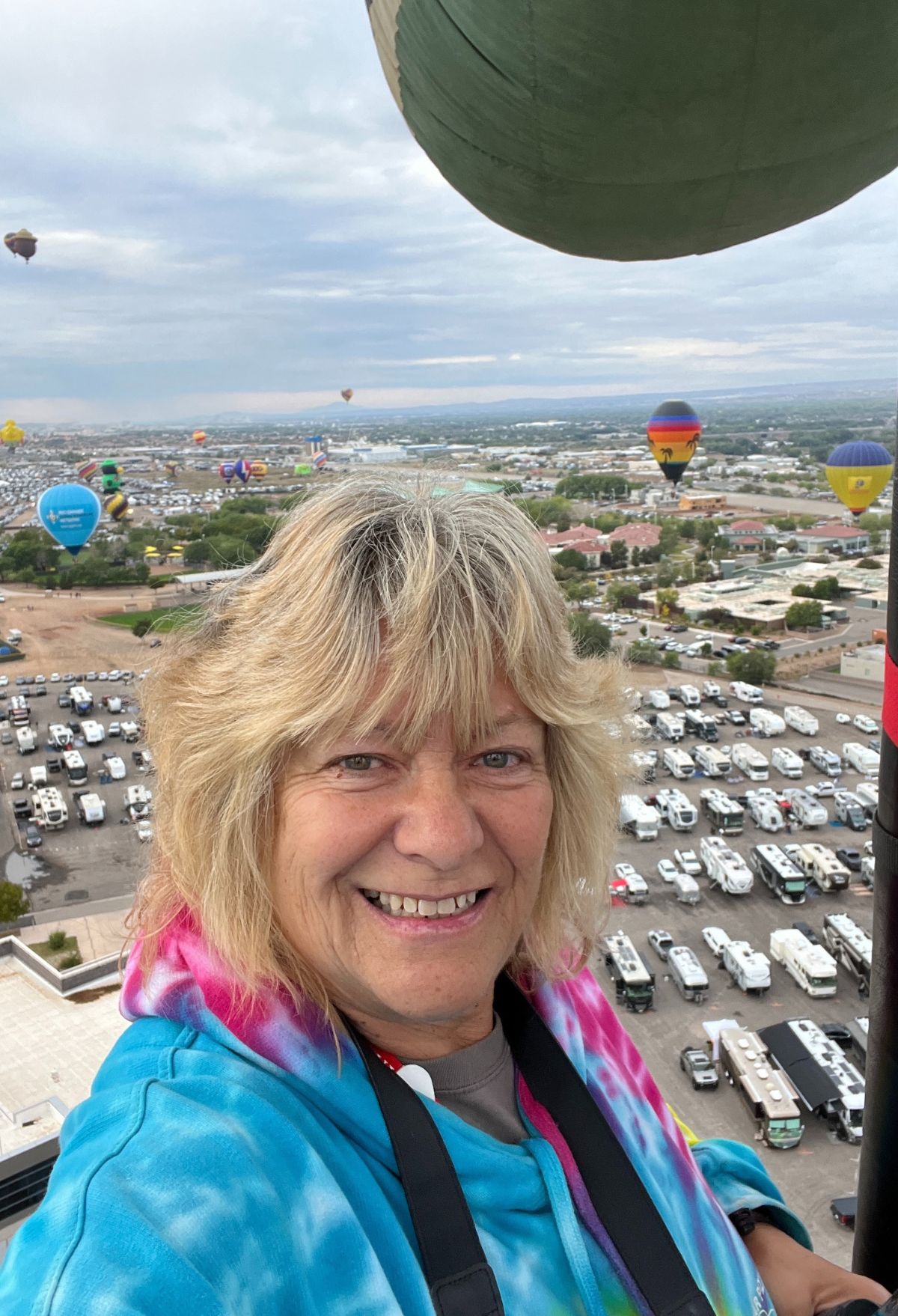 A woman smiling in front of a hot air balloon in santa fe, new mexico.