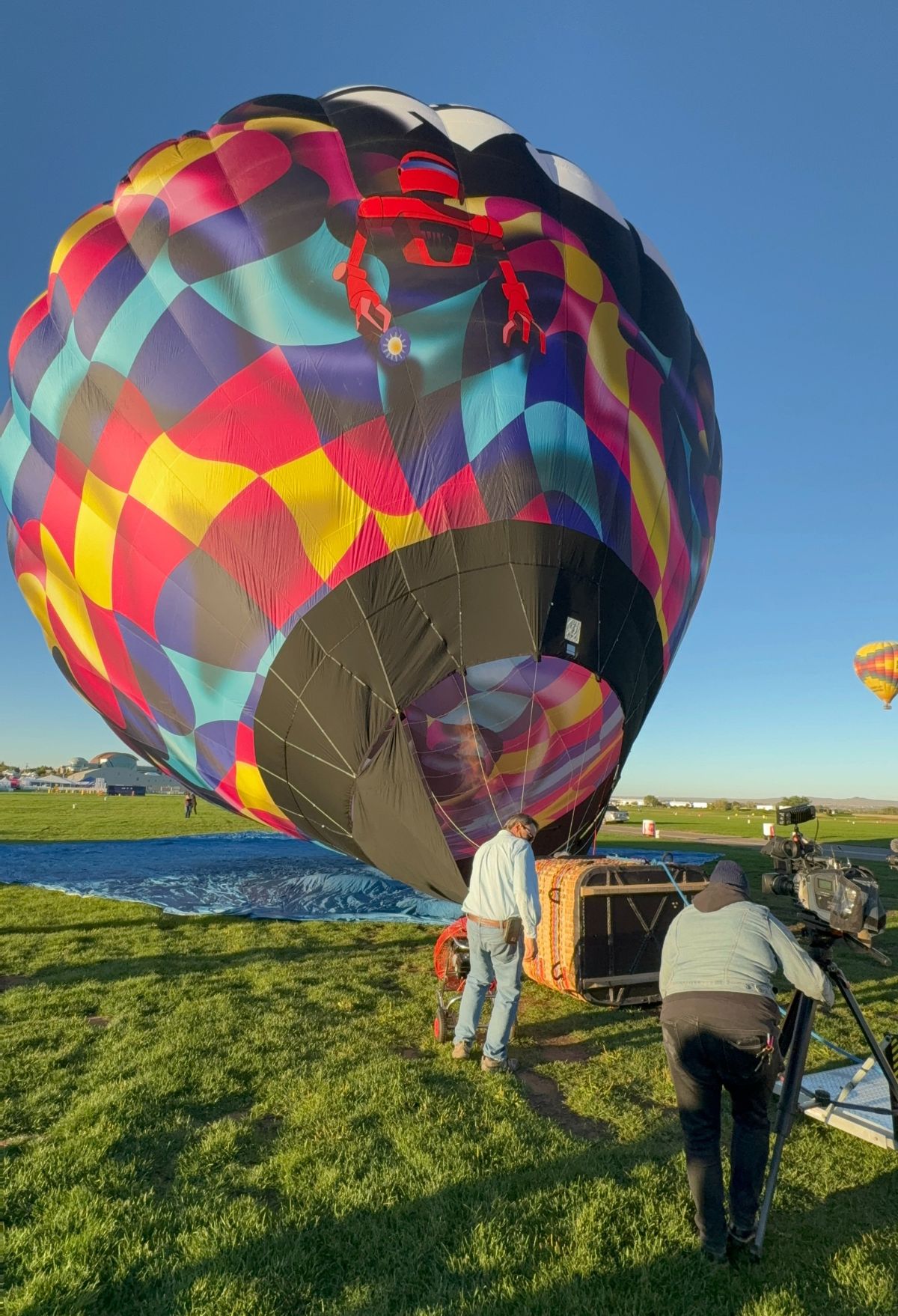 A group of people are filming a hot air balloon.