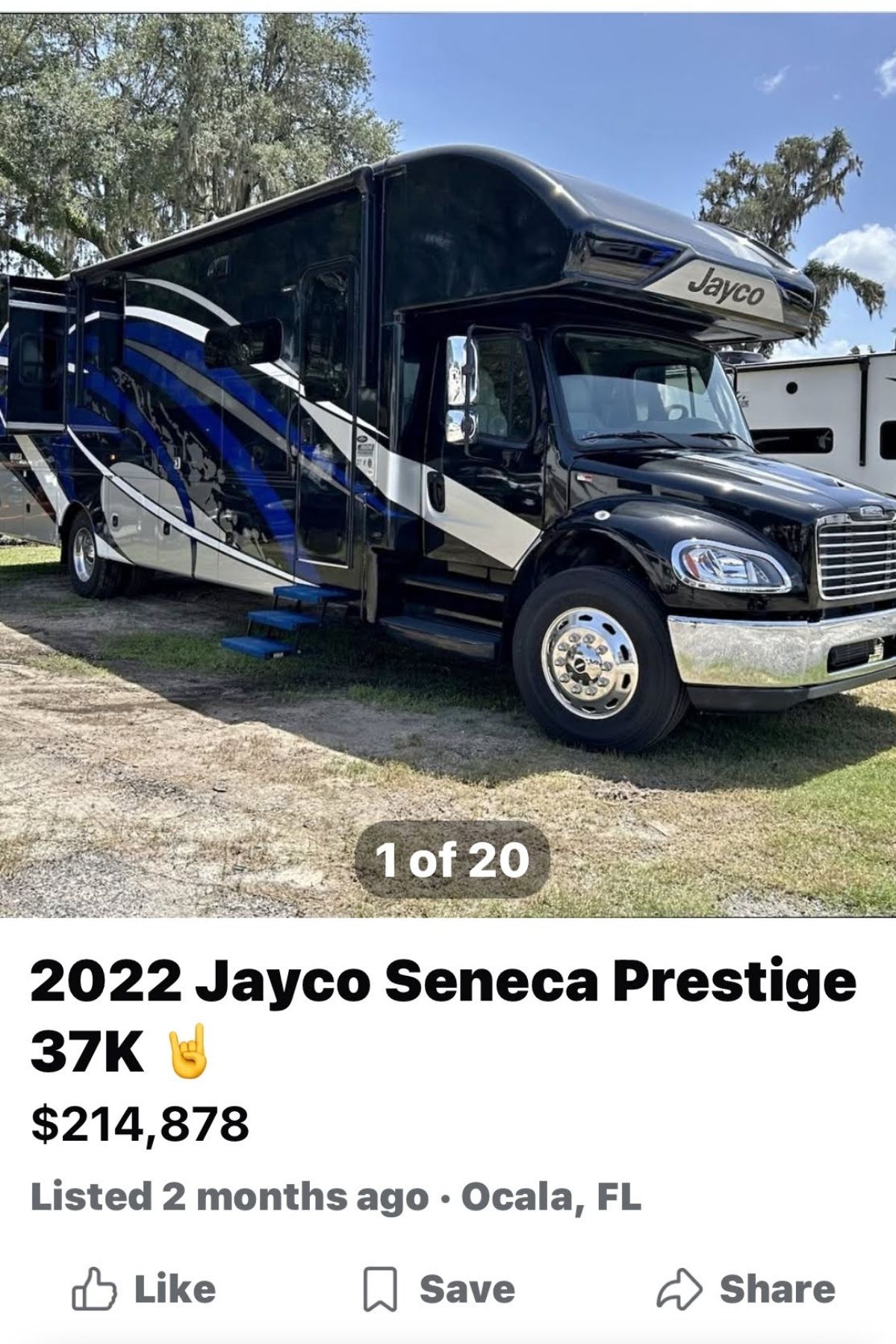 A black and blue 2022 Jayco Seneca Prestige 37K RV is parked on grass, inviting you to buy an RV crafted for both luxury and adventure. Listed for $214,878 in Ocala, FL. Steps are extended, and trees are visible in the background.